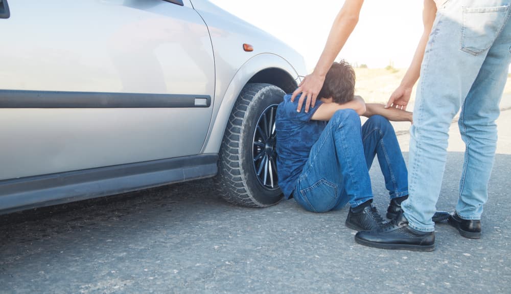 A car driver is helping an accident victim. It's a moment that highlights the intersection of people's lives and the responsibility of car driving.







