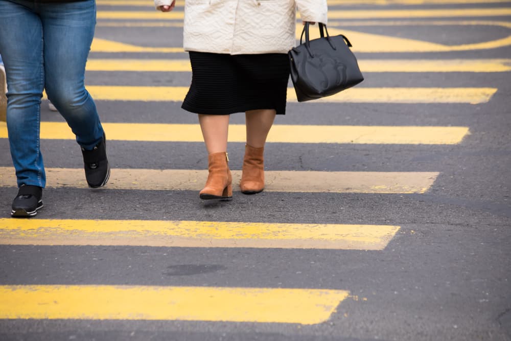 People are crossing the street in the crosswalk.






